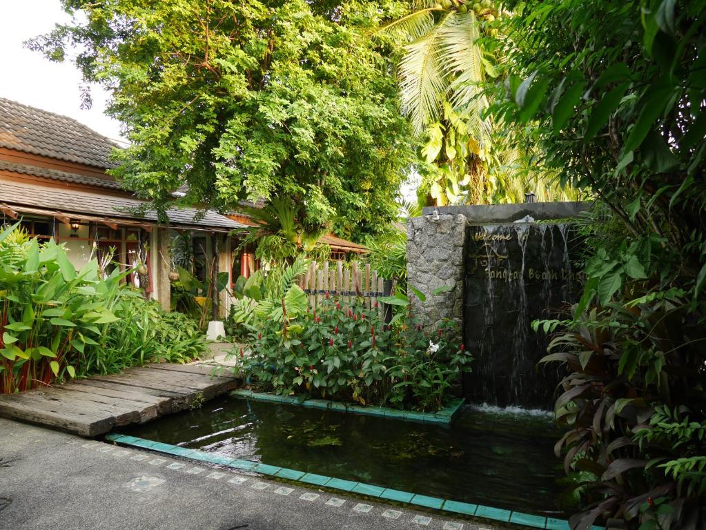 a garden with a pond in the middle of a house at Bangtao Beach Chalet Resort in Bang Tao Beach