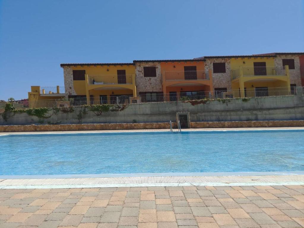a large swimming pool in front of a building at appartamento dentro babai village in Tertenìa