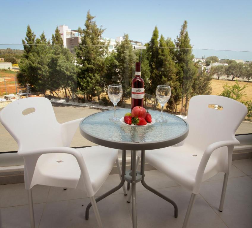 a table with a bottle of wine and a bowl of fruit at Bellini Hotel in Ayia Napa