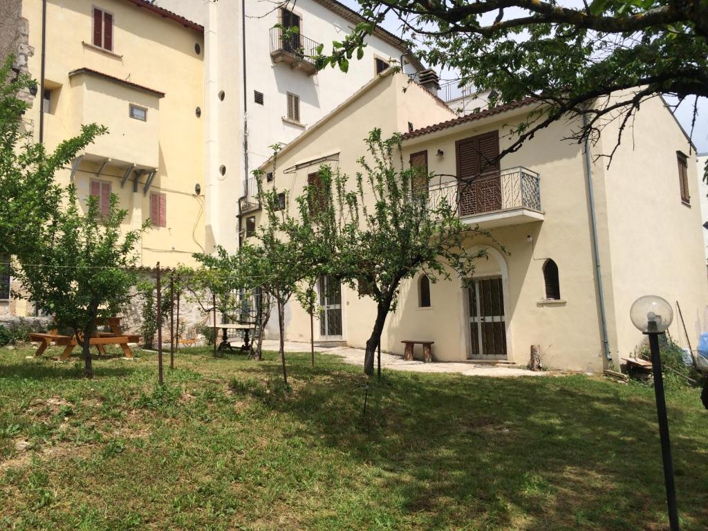 a building with a yard with trees in front of it at Casa vacanze da Medardo in Gagliano Aterno