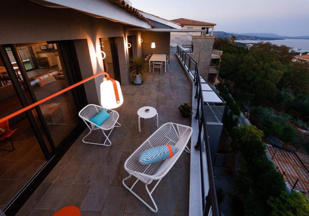 a balcony with chairs and tables on a building at Citta di Lume Suites &amp; Lofts in Porto-Vecchio