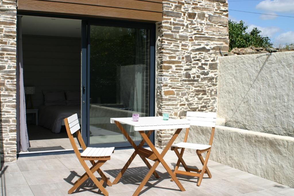 un patio con mesa y 2 sillas en Au gré du Marais - Chambres d'hôtes en Ancenis