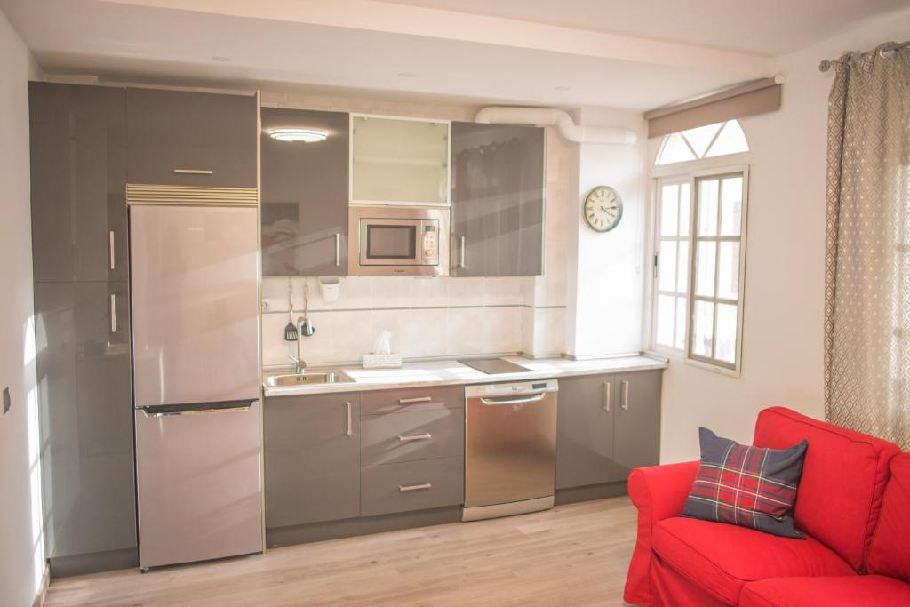 een keuken met een rode bank in een kamer bij Apartamento Padilla Playa Huelin in Málaga