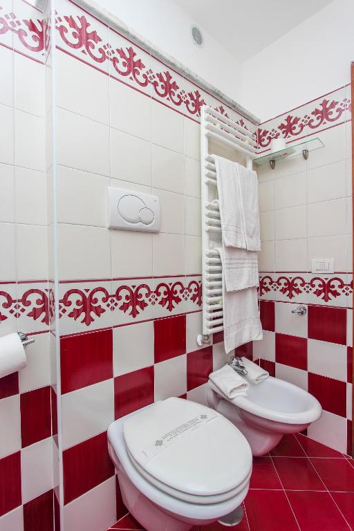 a red and white bathroom with a toilet and a sink at Hotel Bonadies in Ravello