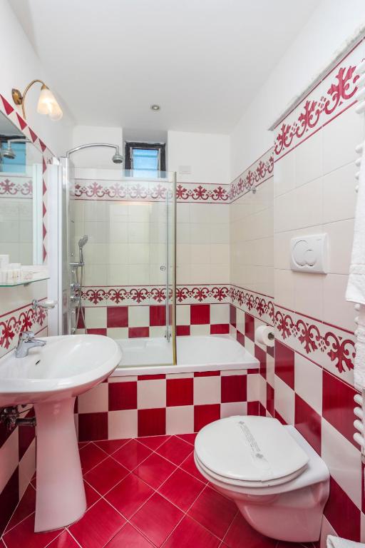 a red and white bathroom with a toilet and a sink at Hotel Bonadies in Ravello