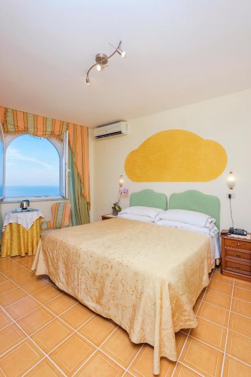 a bedroom with a large bed and a large window at Hotel Bonadies in Ravello
