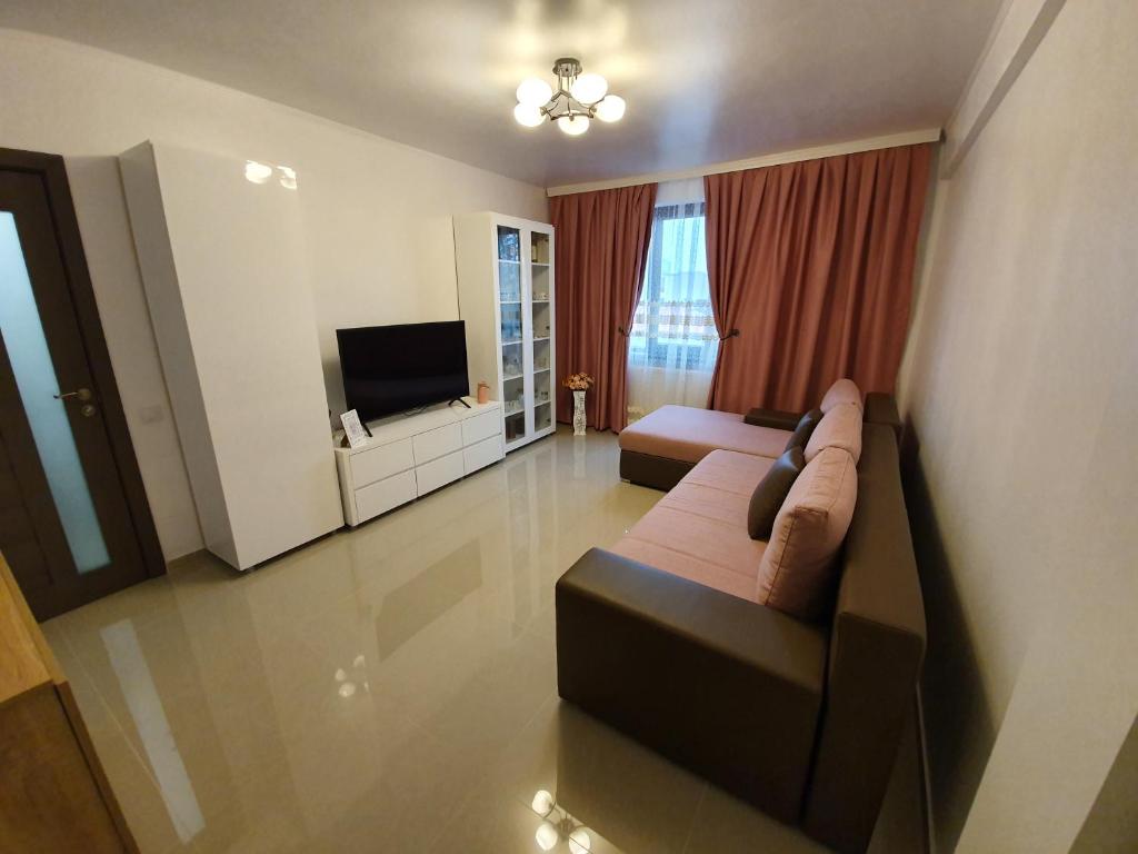 een woonkamer met een bank en een flatscreen-tv bij Apartament Katy Neversea in Constanţa