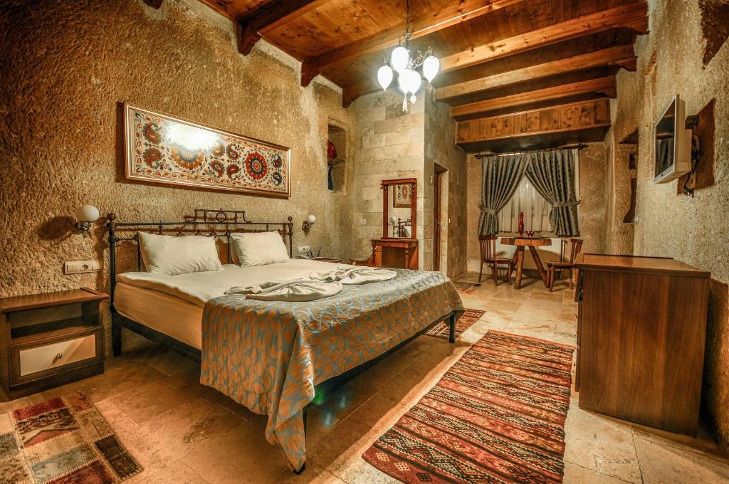 a bedroom with a bed and a table in a room at Nomads Cave Hotel & Rooftop in Goreme