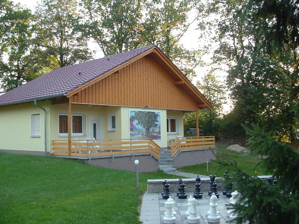 uma pequena casa com um grande tabuleiro de xadrez em frente em Ferienhof Zum Kammergut- Ferienhaus- Ferienwohnung em Zeulenroda