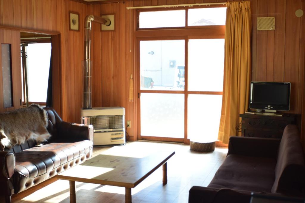 ein Wohnzimmer mit einem Sofa und einem Couchtisch in der Unterkunft Shoei backpackes hostel in Teshikaga