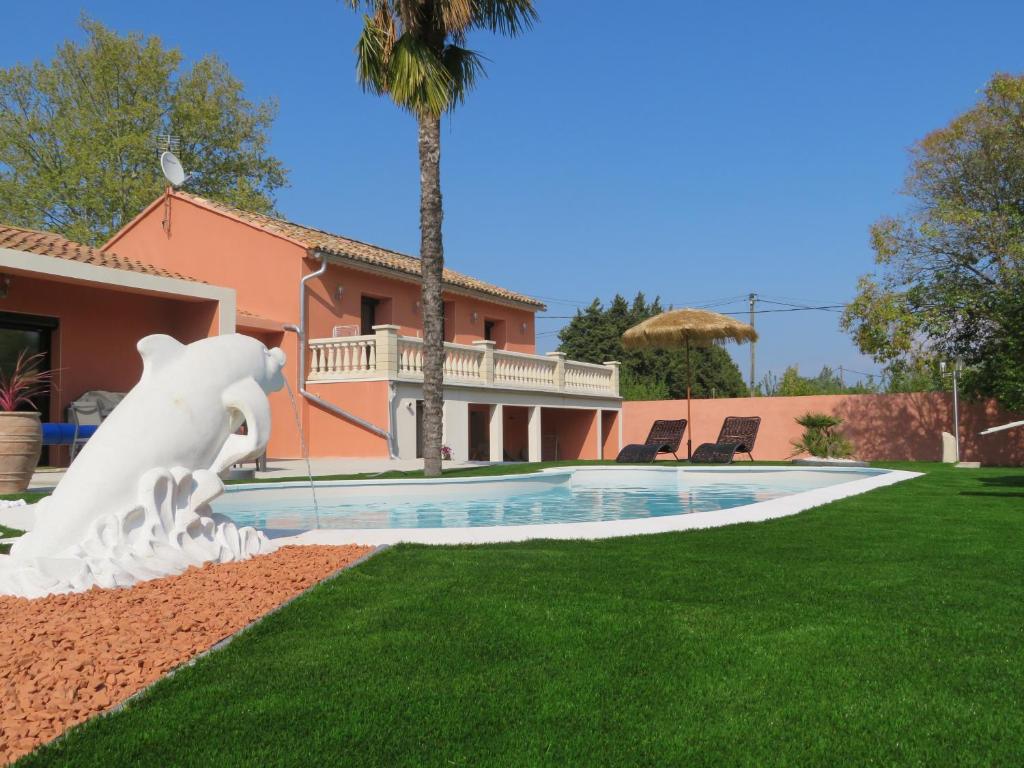 een huis met een zwembad met een paardenbeeld in de tuin bij Maison 4 étoiles et Studio 3 étoiles indépendants avec piscine in LʼIsle-sur-la-Sorgue