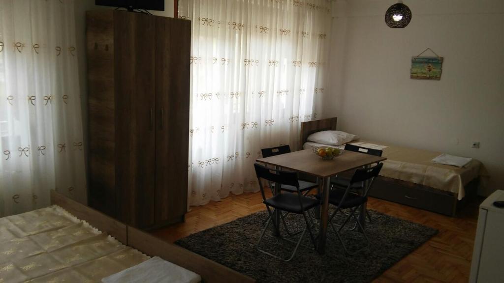mały pokój ze stołem i 2 łóżkami w obiekcie Apartments Struga w mieście Struga