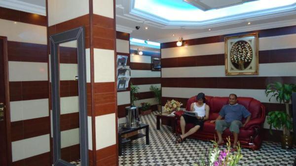 a man and woman sitting on a couch in a lobby at Sport Hotel in Dubai