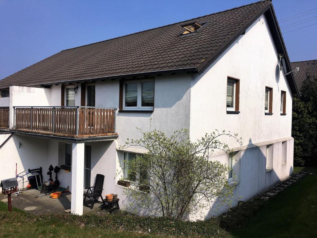 a white house with a deck on the side of it at Ferien Wohnung in der Eifel in Nideggen-Schmidt in Schmidt