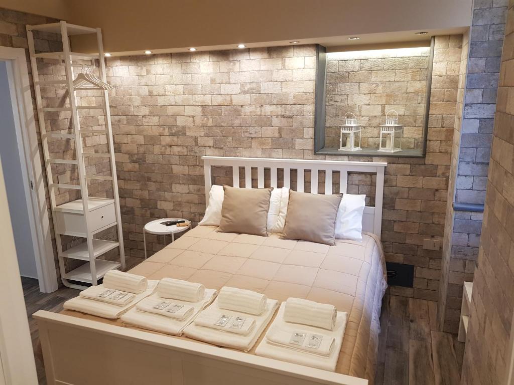 ein Schlafzimmer mit einem Bett mit vier Kissen darauf in der Unterkunft VENTIMIGLIA SUITE & WINE in Catania