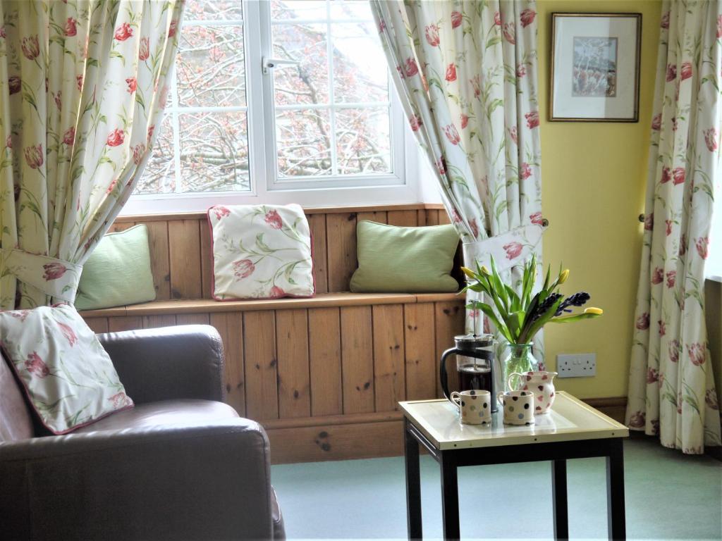 a window seat in a living room with a couch and a table at Rectory Farm in Levisham