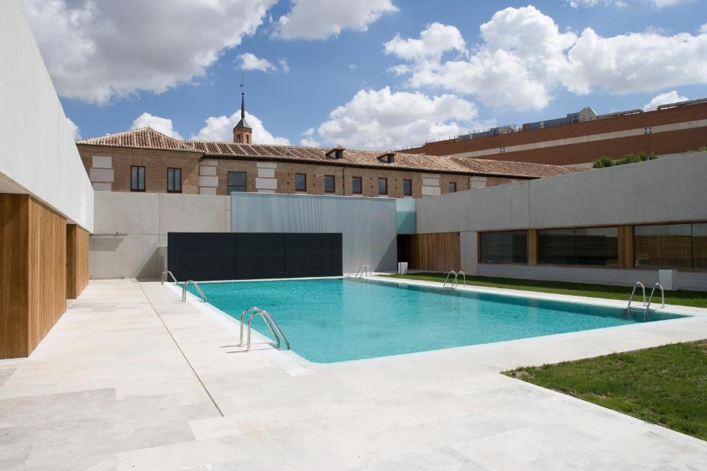 a swimming pool on the side of a building at Parador de Alcalá de Henares in Alcalá de Henares