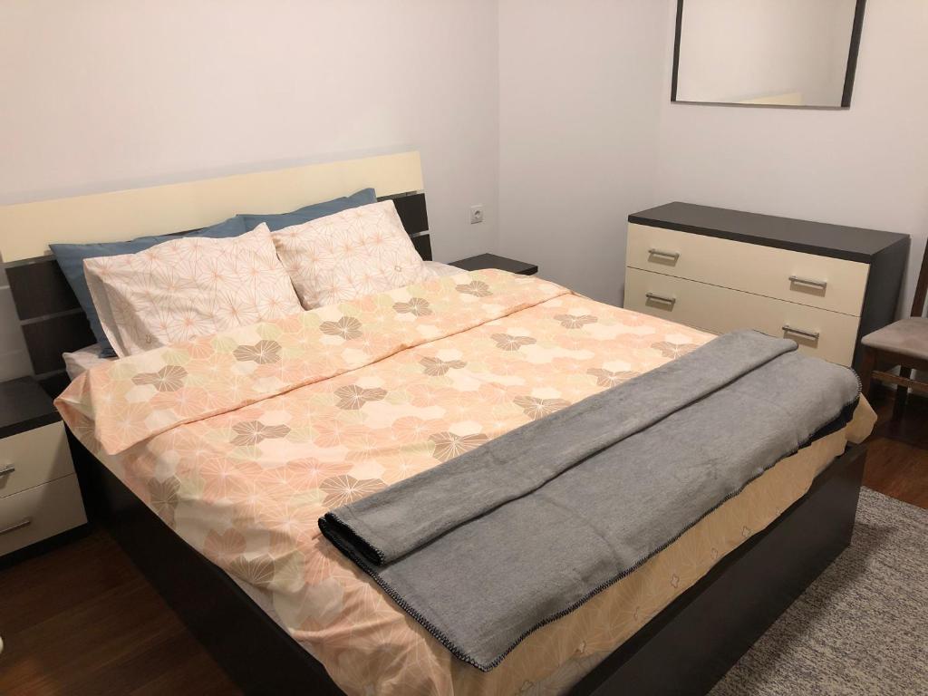 a bed with a blanket on it in a bedroom at Apartment Prishtina in Prishtinë