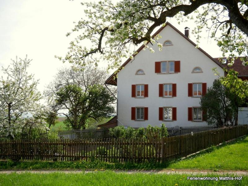 a white house with red windows and a fence at Matthis-Hof in Waldshut-Tiengen