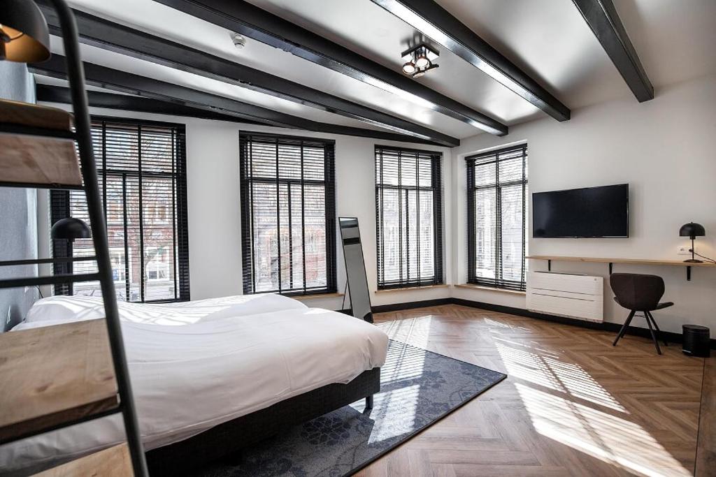 a bedroom with a bed and a flat screen tv at Boutique hotel WKNDS in Leeuwarden