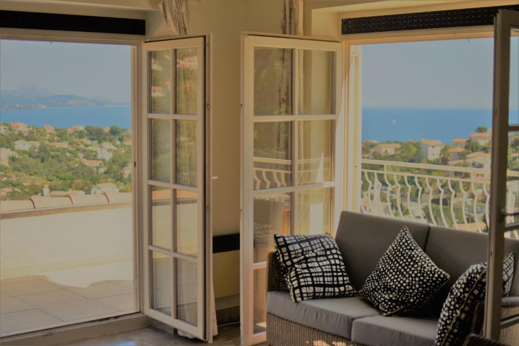 un salon avec un canapé et des portes coulissantes en verre dans l'établissement Les Myrtes, aux Issambres