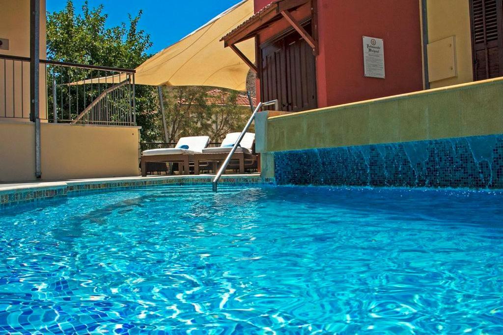 a large swimming pool in front of a building at The Library Hotel Wellness Retreat in Kalavasos