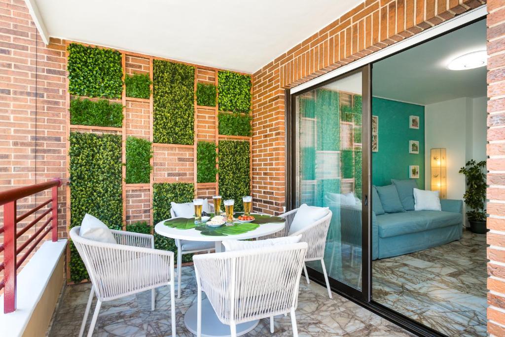 a patio with a table and chairs and a green wall at Apartamento AGUA MARINA Levante Beach in Benidorm