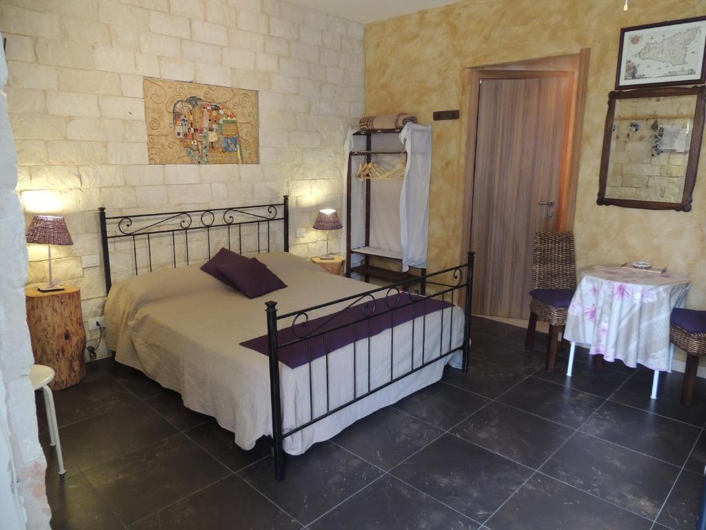 拉古薩的住宿－Monolocale l'Abbraccio，卧室配有一张床和一张桌子及椅子