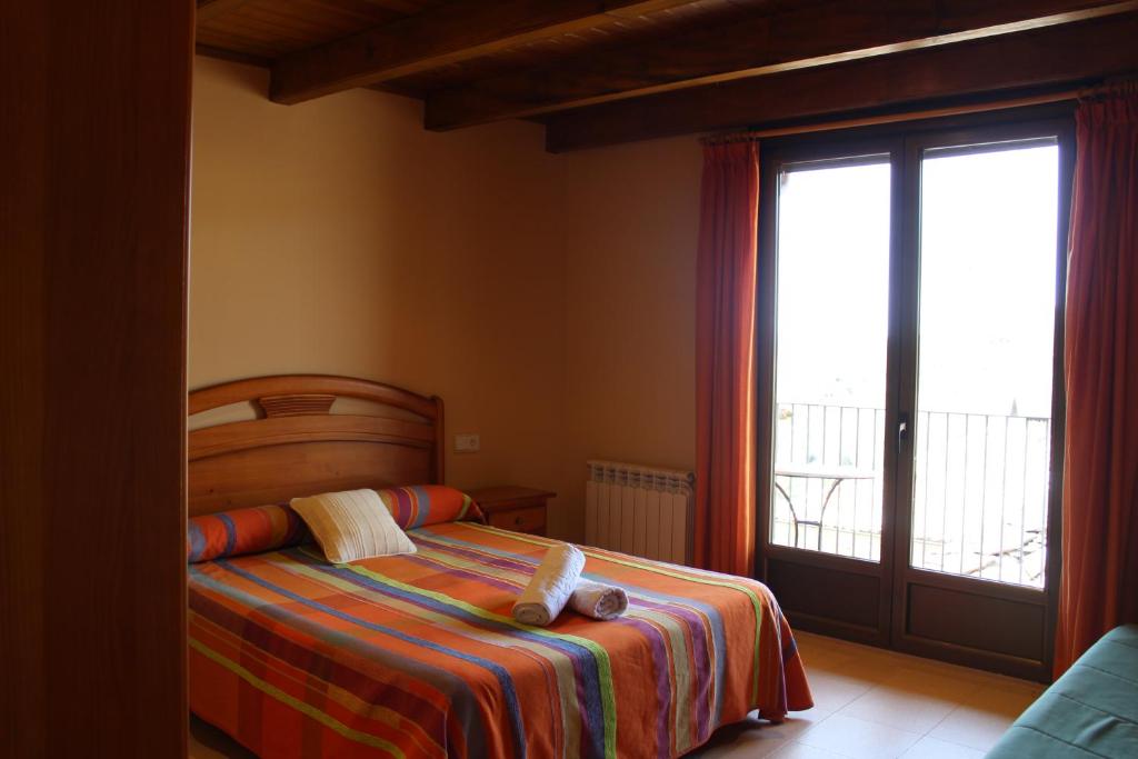 um quarto com uma cama e uma grande janela em Allotjament Rural Casa Bernat em Sapeira