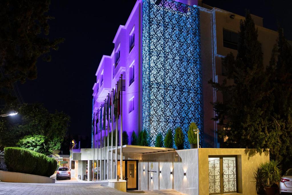 a building lit up in purple at night at Amman International Hotel in Amman