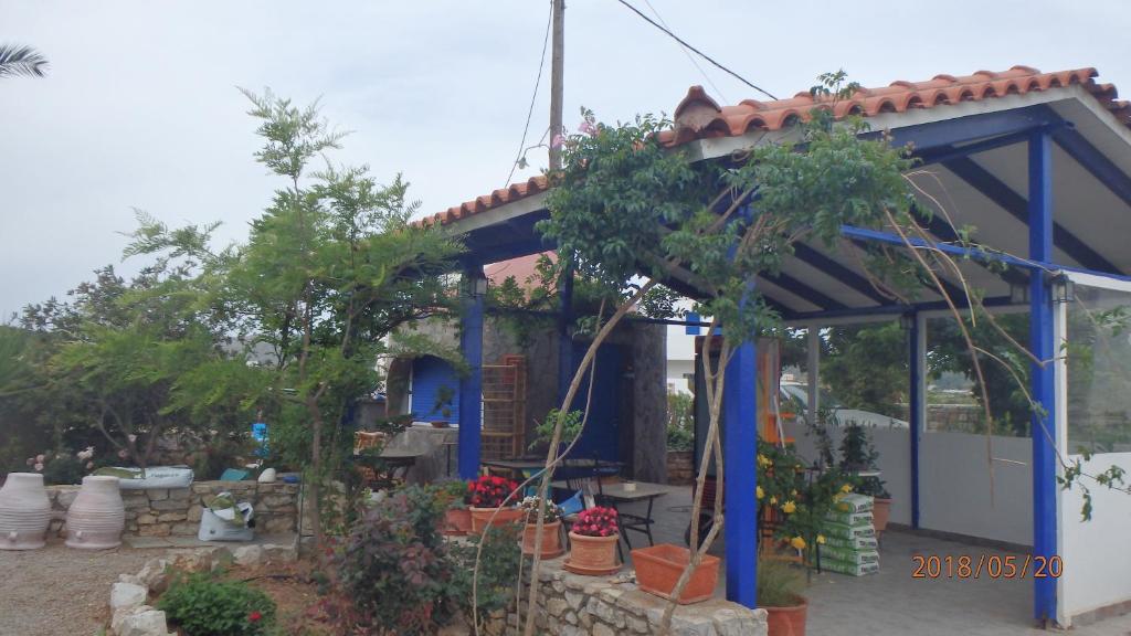 a small blue building with trees and potted plants at Mylos Garden in Livadi