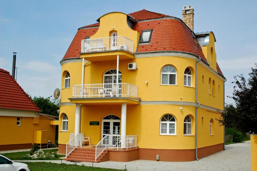 a yellow house with a red roof at Kastely Panzio II. in Hajdúszoboszló
