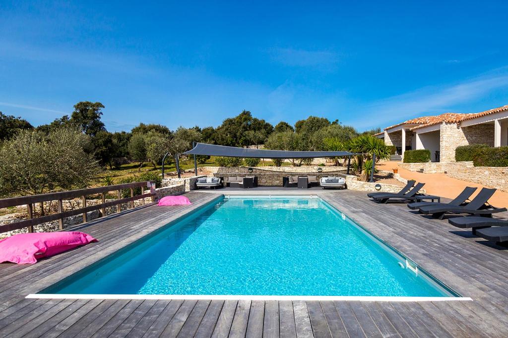 a swimming pool with chairs and a house at l'Albitru in Bonifacio