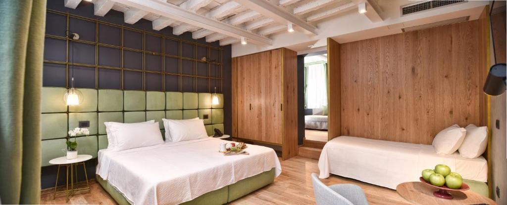 ヴェネツィアにあるHotel Maison Ducalのベッド2台とテーブルが備わるホテルルームです。