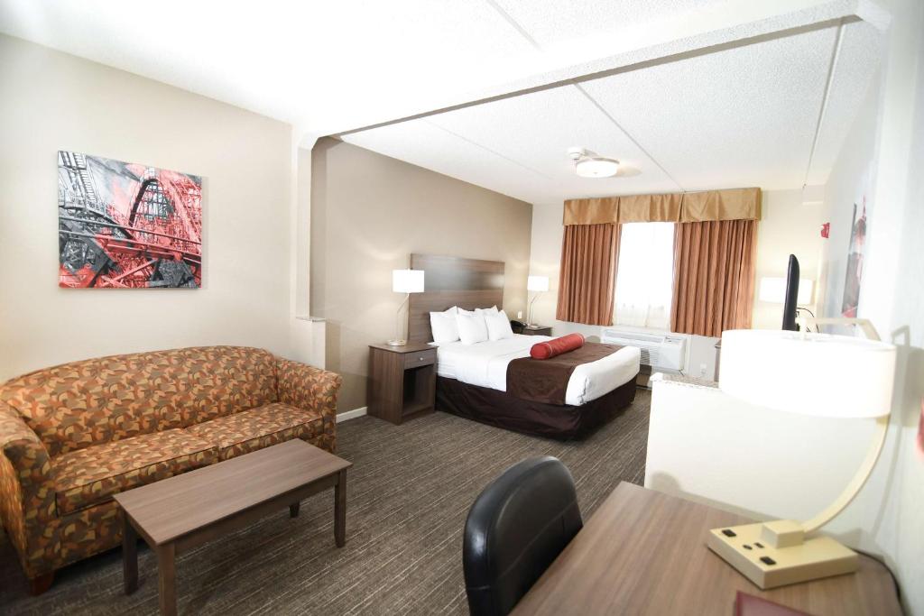 a hotel room with a bed and a couch at Best Western Plus Sandusky Hotel & Suites in Sandusky