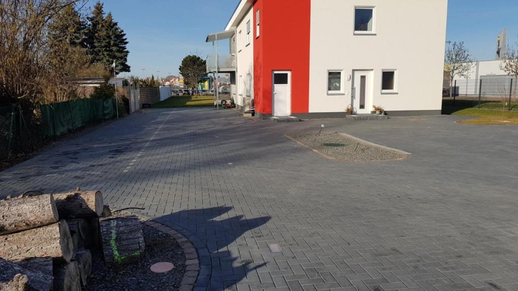 een parkeerplaats naast een rood-wit gebouw bij Ferien-Haus-Leipzig in Leipzig