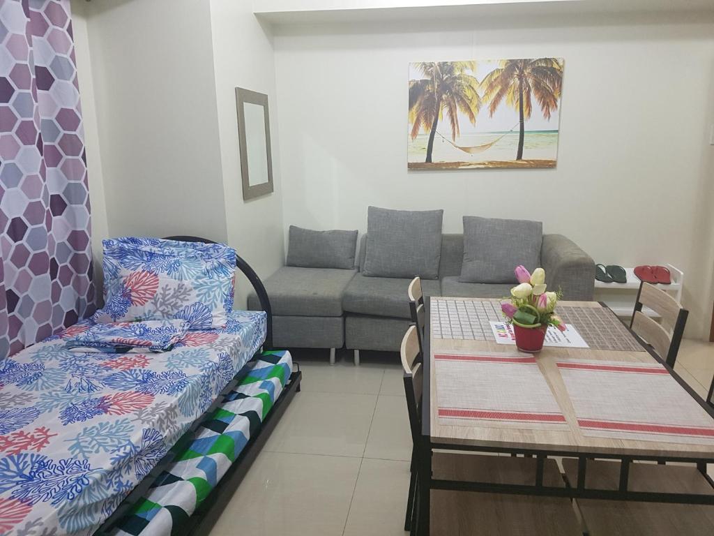 een woonkamer met een tafel en een bank bij KC 1-Bedroom 1 at Horizon 101 Cebu in Cebu City
