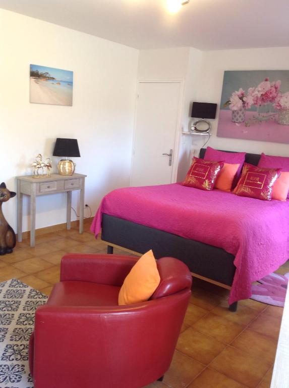 een slaapkamer met een bed en een stoel bij Charmant Appartement 2 pièces in Eccica-Suarella