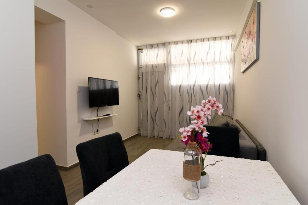 ein Zimmer mit einem Tisch mit einer Blumenvase darauf in der Unterkunft Apartment PAOLA in Zadar