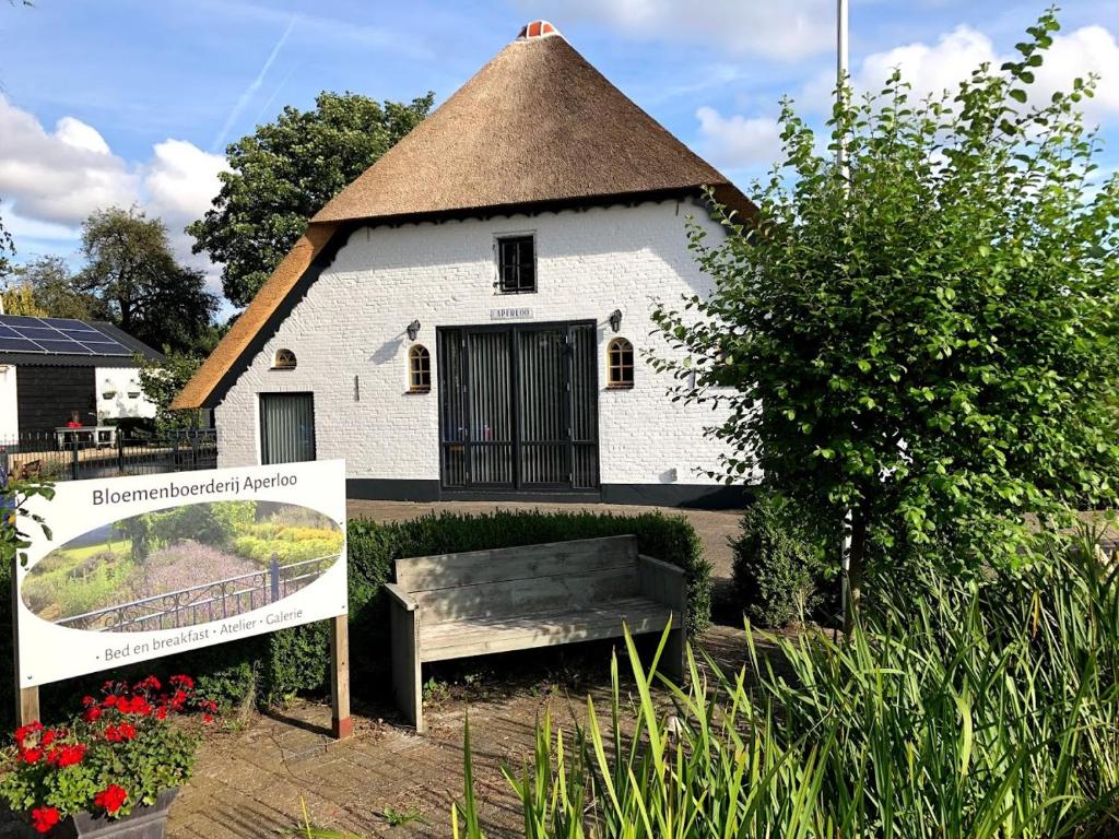 een gebouw met een bank ervoor bij Bloemenboerderij Aperloo in Aperloo