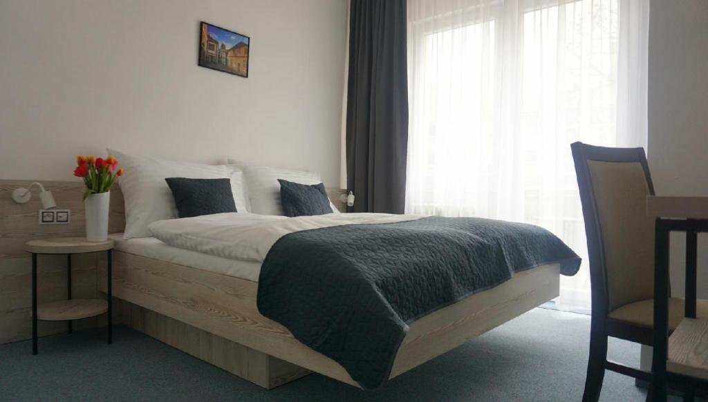 sypialnia z łóżkiem i oknem w obiekcie Hotel Metropol CB w Czeskich Budziejowicach