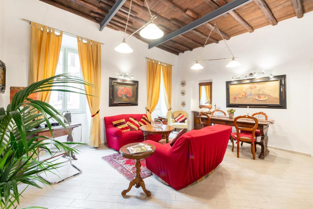 a living room with a red couch and a table at Sistina House Style HolidayHome x 6 in Rome