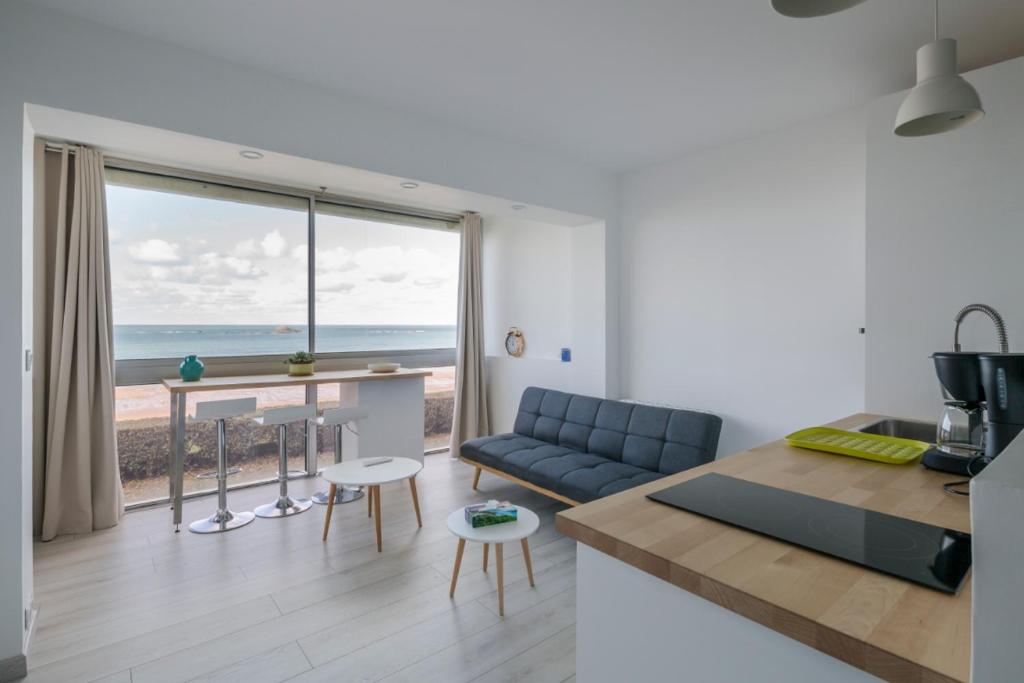 a kitchen and living room with a view of the ocean at Ker Romain - Studio - Vue Mer 180 degres in Saint Malo