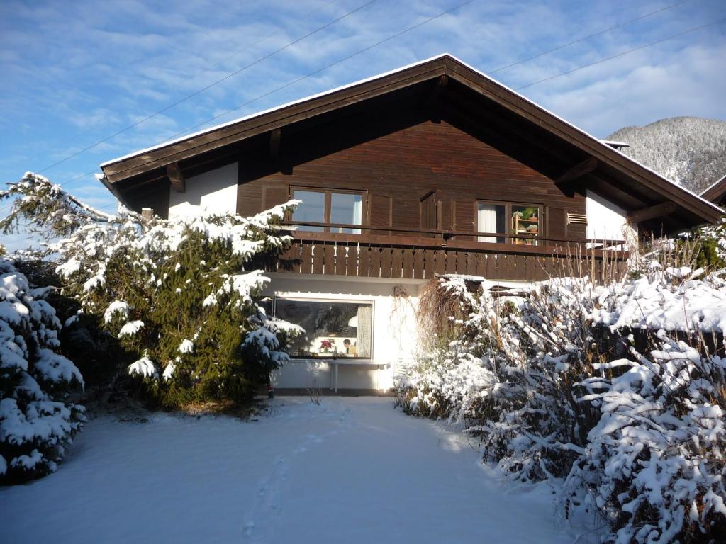 una casa con un patio cubierto de nieve delante de ella en Ferienhaus Werthmann, en Mittenwald