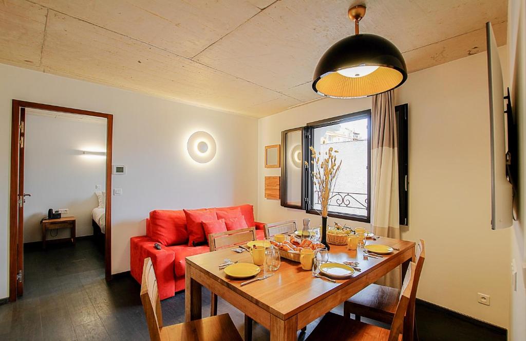 a living room with a table and a red couch at Residence Kalliste in Ajaccio