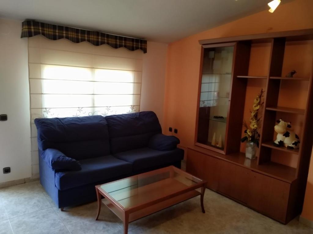 a living room with a blue couch and a coffee table at APARTAMENTO QUINTO in Valderrobres
