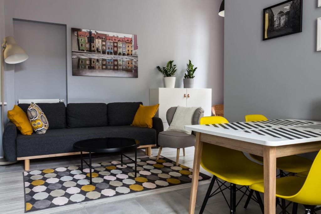 uma sala de estar com um sofá e cadeiras amarelas em Apartament Jana Matejki em Poznań