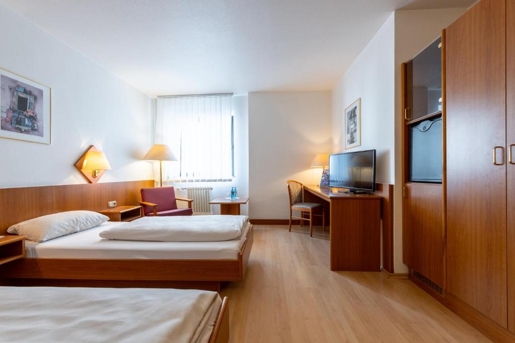 ein Hotelzimmer mit 2 Betten und einem TV in der Unterkunft Trip Inn Hotel Frankfurt Airport Rüsselsheim in Rüsselsheim