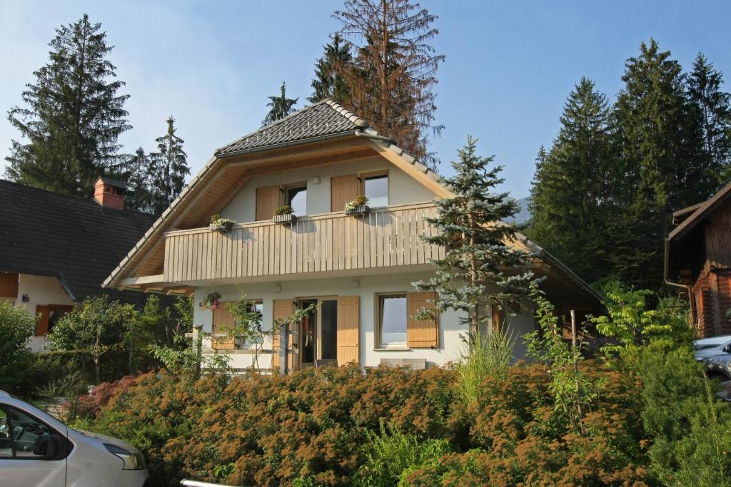 a white house with a gambrel roof at Apartma - Počitniška hiša Lodi in Bohinj