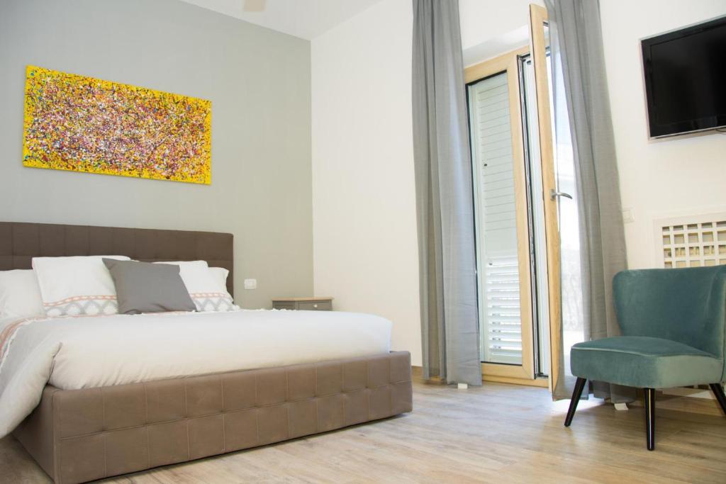 - une chambre avec un lit, une télévision et une chaise dans l'établissement VILLA MATILDA luxury B&B, à Ischia